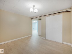 Room featuring light wood-finish flooring, neutral-toned walls, and a white ceiling with a flush-mount light fixture - 