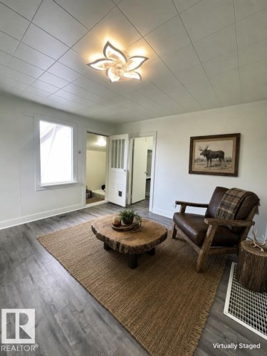 Interior room with wood-finish flooring and a decorative ceiling light fixture - 4912 49 Avenue, Onoway, AB 