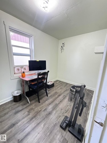 Room featuring wood-finish flooring, light-toned walls, and a window for natural illumination - 4912 49 Avenue, Onoway, AB 