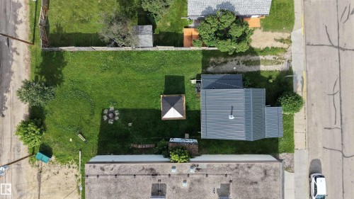 Expansive backyard featuring a manicured lawn, a fire pit area, and a gazebo - 4912 49 Avenue, Onoway, AB 