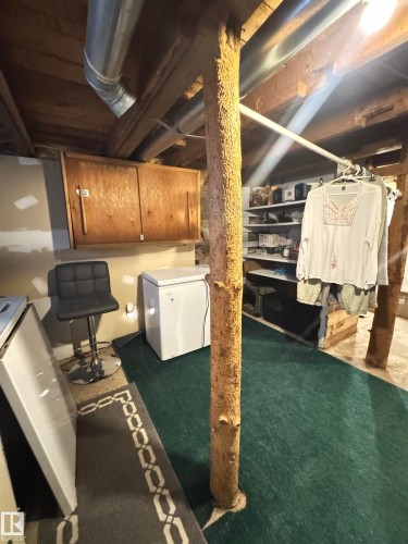 Exposed ceiling joists with visible ductwork and a robust support beam - 4912 49 Avenue, Onoway, AB 