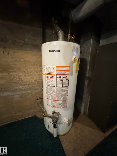 Hotpoint water heater installation with visible piping and ductwork - 4912 49 Avenue, Onoway, AB 