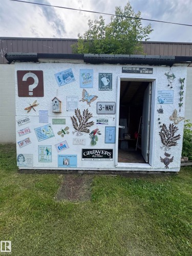 White exterior with a collection of decorative signs and wall art - 4912 49 Avenue, Onoway, AB 