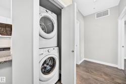 White stacked washer and dryer unit within a dedicated closet - 