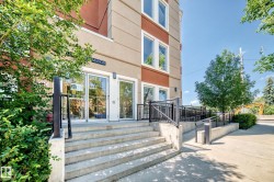 Building entrance featuring concrete steps and an integrated access ramp with black metal railings - 