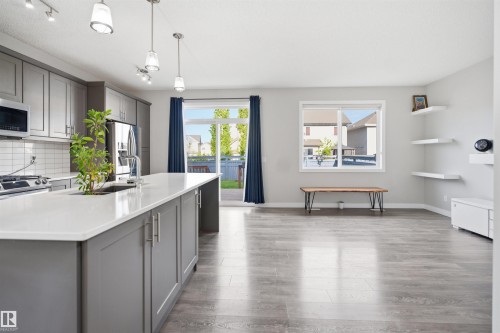 Open-concept living space featuring wood-finish flooring and light gray walls - 1234 Daniels Crescent, Edmonton, AB - Indoor Photo Showing Kitchen With Upgraded Kitchen