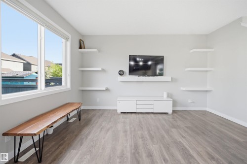 Open-concept living area featuring light wood-finish flooring, a large picture window, and recessed lighting - 1234 Daniels Crescent, Edmonton, AB - Indoor Photo Showing Other Room