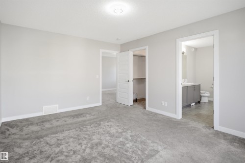 Neutral gray walls with white trim, gray textured carpeting, and a flush mount ceiling light - 1234 Daniels Crescent, Edmonton, AB - Indoor
