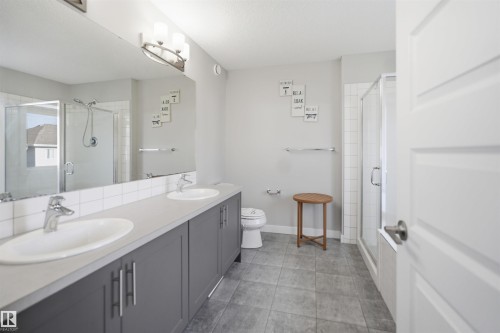 Dual vanity with undermount sinks, gray cabinetry, and light-toned countertops - 1234 Daniels Crescent, Edmonton, AB - Indoor Photo Showing Bathroom