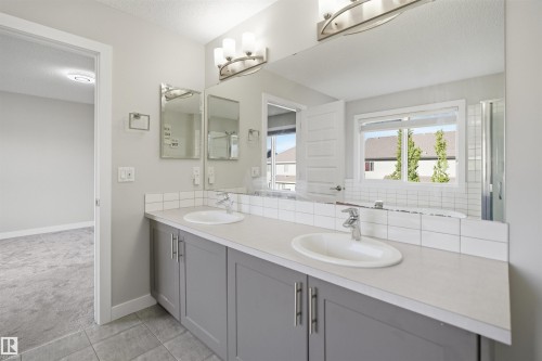 Double vanity with light gray cabinetry, white countertops, and dual undermount sinks - 1234 Daniels Crescent, Edmonton, AB - Indoor Photo Showing Bathroom