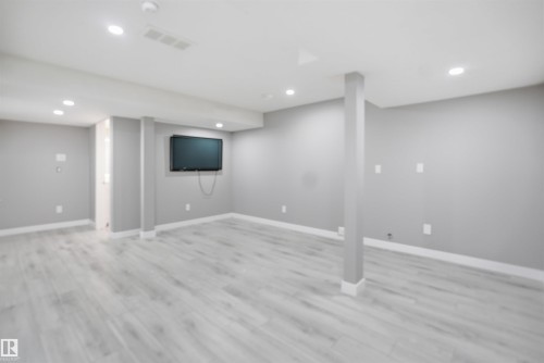 Spacious interior room featuring light-toned wood-finish flooring, recessed lighting, painted walls, and white trim - 1234 Daniels Crescent, Edmonton, AB - Indoor