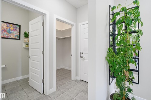 Entryway featuring light gray tile flooring, crisp white trim, and white paneled doors - 1234 Daniels Crescent, Edmonton, AB - Indoor Photo Showing Other Room