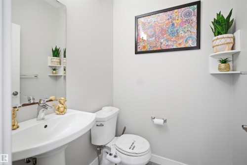 Pedestal sink with chrome faucet, large wall mirror, and light gray wall paint - 1234 Daniels Crescent, Edmonton, AB - Indoor Photo Showing Bathroom