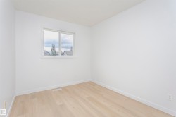 Bright interior space featuring a window, light wood-finish flooring, white baseboards, and white walls - 