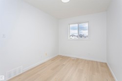 Neutral color palette featuring wood-finish flooring, white baseboards, and a white ceiling - 
