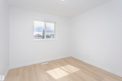 Bright interior space featuring light wood-finish flooring and a white trim package - 