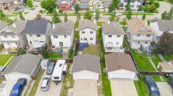 Residential properties featuring two-story designs, asphalt shingle roofs, and detached garages - 