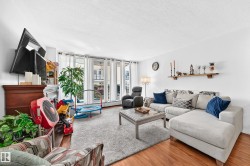 Living area with wood-finish flooring, a built-in fireplace, and expansive windows - 