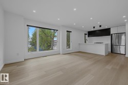 Open-concept living space featuring wood-finish flooring and recessed lighting - 