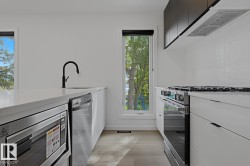 Modern kitchen featuring white cabinetry, light wood-finish flooring, and white countertops - 