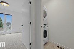 Dedicated laundry area featuring a stacked washer and dryer unit - 