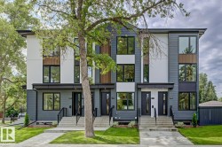 Modern townhome exterior featuring multi-toned siding, large black-framed windows, and a concrete walk-up with black railings - 