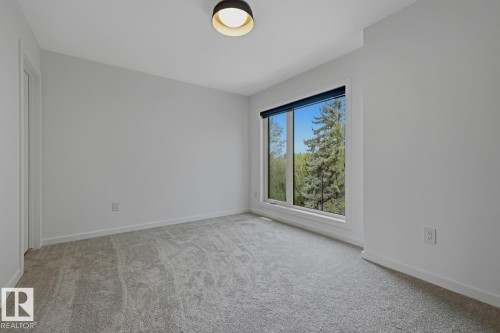 Bright bedroom with light gray carpeting and white baseboards - 8903 94 Ave Nw, Edmonton, AB 