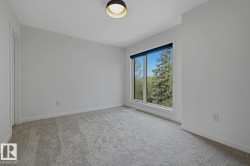 Bright bedroom with light gray carpeting and white baseboards - 