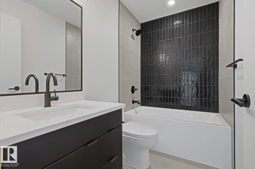 Contemporary bathroom featuring a dark tile shower surround, a white built-in tub, a dark vanity with a white countertop, and matte black fixtures - 8903 94 Ave Nw, Edmonton, AB 
