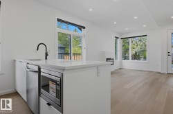Modern kitchen island featuring a white quartz countertop, integrated stainless steel dishwasher, and built-in microwave - 