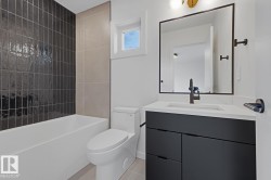 Contemporary bathroom featuring a dark grey vanity with a white countertop and rectangular undermount sink - 