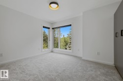 Bright room featuring a modern flush-mount ceiling light fixture, light gray carpeting, and white trim - 