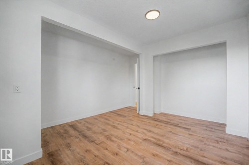 Neutral white walls, wood-finish flooring, recessed ceiling lighting, and deep wall recesses - 60 Mcnabb Crescent, Stony Plain, AB - Indoor Photo Showing Other Room