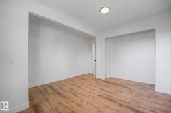 Neutral white walls, wood-finish flooring, recessed ceiling lighting, and deep wall recesses - 
