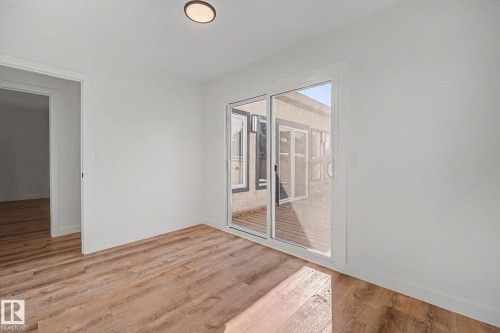 Open room featuring wood-finish flooring, white baseboards, and a flush-mount ceiling light - 60 Mcnabb Crescent, Stony Plain, AB - Indoor Photo Showing Other Room