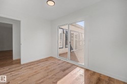 Open room featuring wood-finish flooring, white baseboards, and a flush-mount ceiling light - 