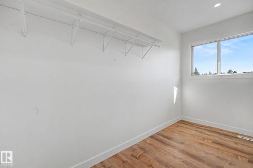 Room featuring a single window, recessed ceiling lighting, a wood-finish floor, and a built-in wall shelf - 60 Mcnabb Crescent, Stony Plain, AB - Indoor