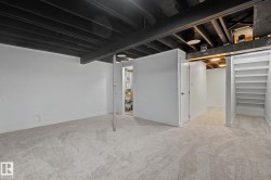 Carpeted room with white walls, exposed black ceiling joists, and a metal support column - 