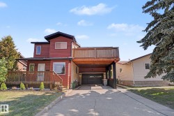 Multi-level home featuring red siding and a light-colored stucco finish - 