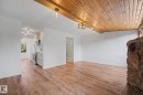 Open-concept living area featuring wood-finish flooring and a wood-paneled ceiling with exposed beams - 60 Mcnabb Crescent, Stony Plain, AB  - Indoor 