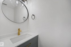 Bathroom vanity featuring a gold-finish faucet, integrated rectangular sink, white countertop, and gray cabinetry with gold-finish hardware - 