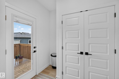 Full-lite door offering outdoor access to a wood deck with a privacy fence - 548 Kleins Crescent, Leduc, AB 
