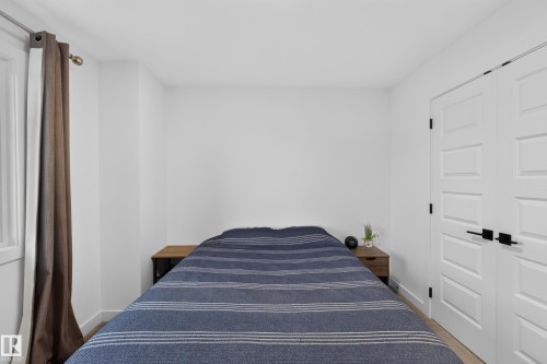 Bedroom featuring light-toned flooring, bright white walls, and a window with a curtain rod - 548 Kleins Crescent, Leduc, AB 