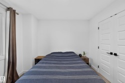 Bedroom featuring light-toned flooring, bright white walls, and a window with a curtain rod - 