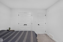 White paneled doors with matte black hardware, light neutral carpeting, white baseboards, and bright white walls - 