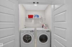 Dedicated laundry area featuring a front-loading washer and dryer set, overhead wire shelving, and bright overhead lighting - 