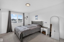 Bedroom featuring a large window, carpeted flooring, and a flush-mount ceiling light - 