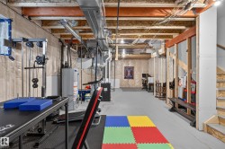 Unfinished basement space with exposed wood joists and structural beams - 