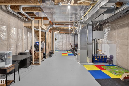 Unfinished basement featuring exposed wood framing, ductwork, and overhead lighting - 548 Kleins Crescent, Leduc, AB 