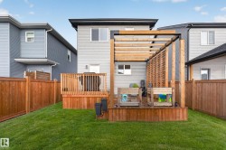 Private backyard featuring a wooden deck with railing, a pergola structure, and a wooden privacy screen - 